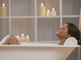 Задоволена жінка лежить у ванні зі свічками