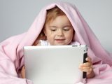 Маленька дитини граэться на планшеті