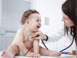 Лікар педіатр оглядає дитину