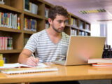 Парень студент изучает польский с ноутбуком